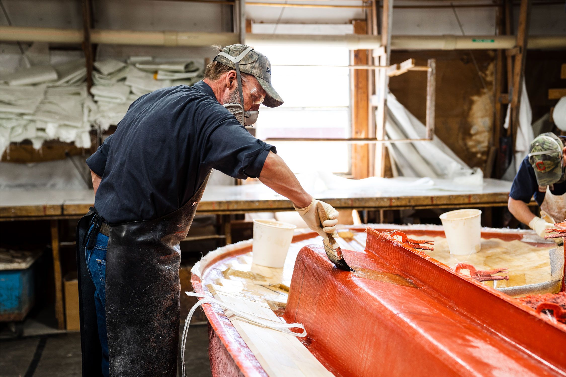man staining a sailboat