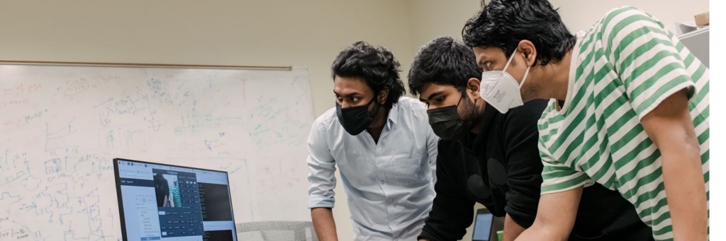 Three men looking at computer