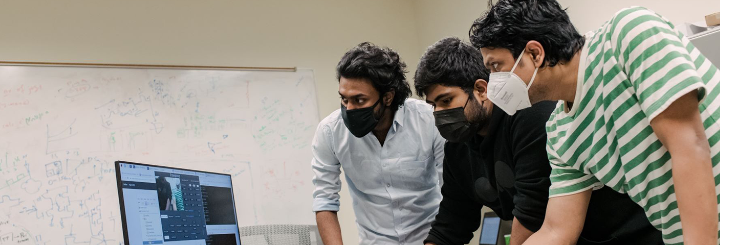 Three men looking at computer