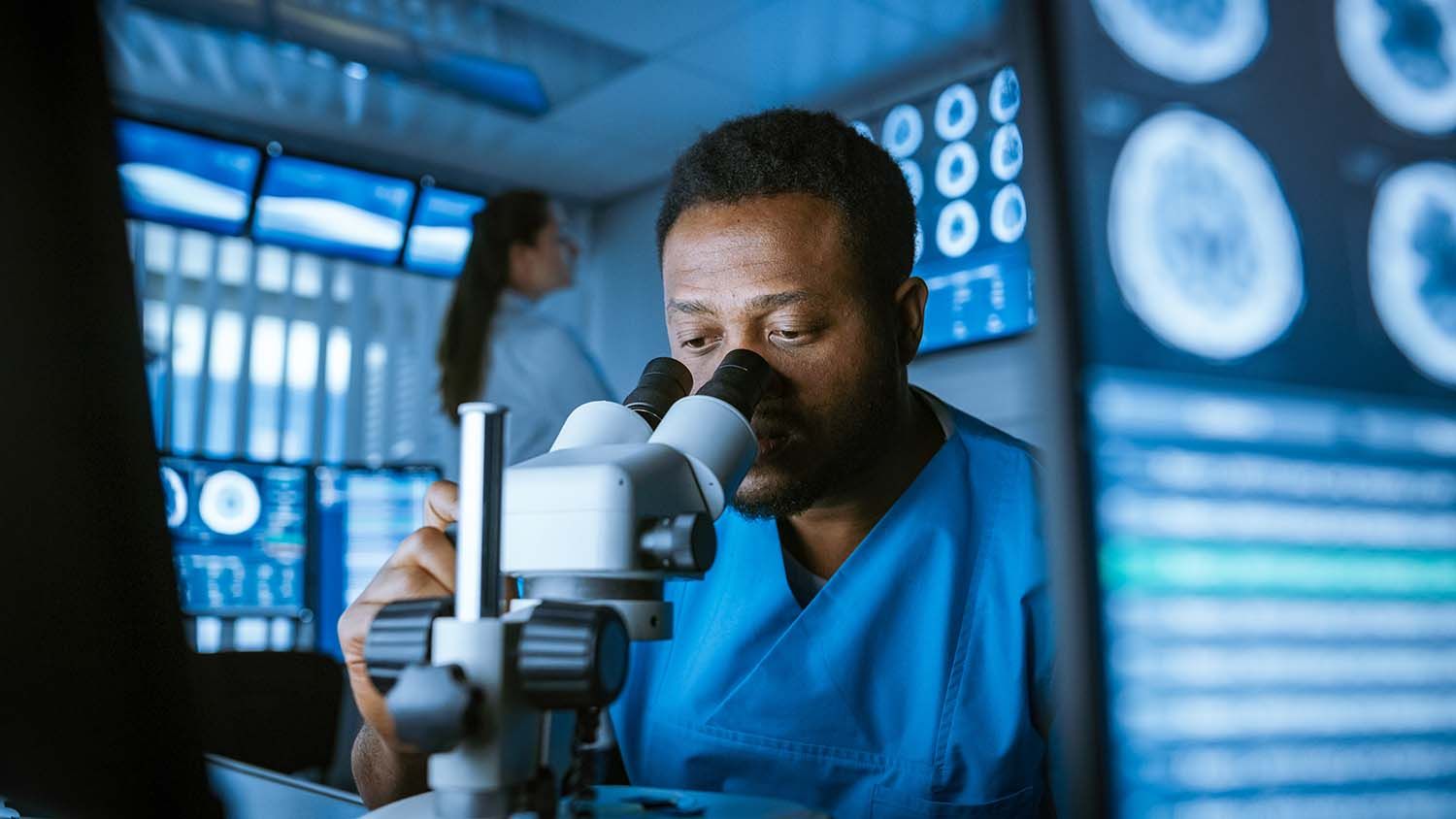 Scientist looking into microscope