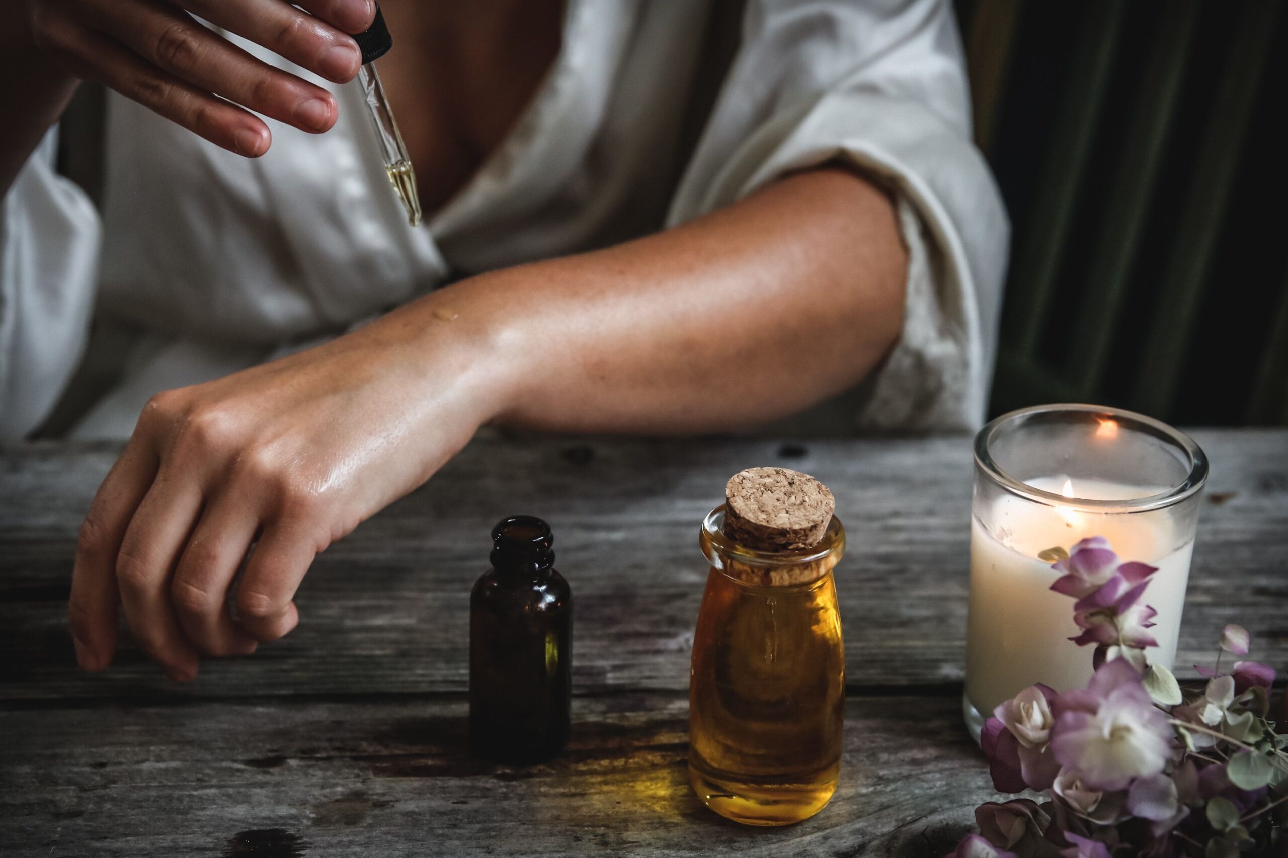 woman with skin products and candle