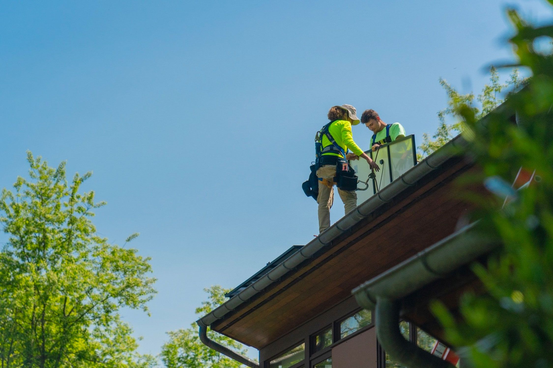 Workers installing solar panels on a roof
