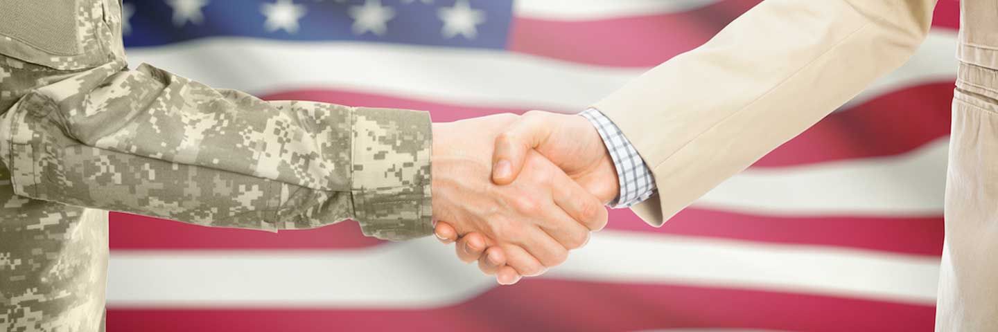 Veteran shaking hands in front of American flag