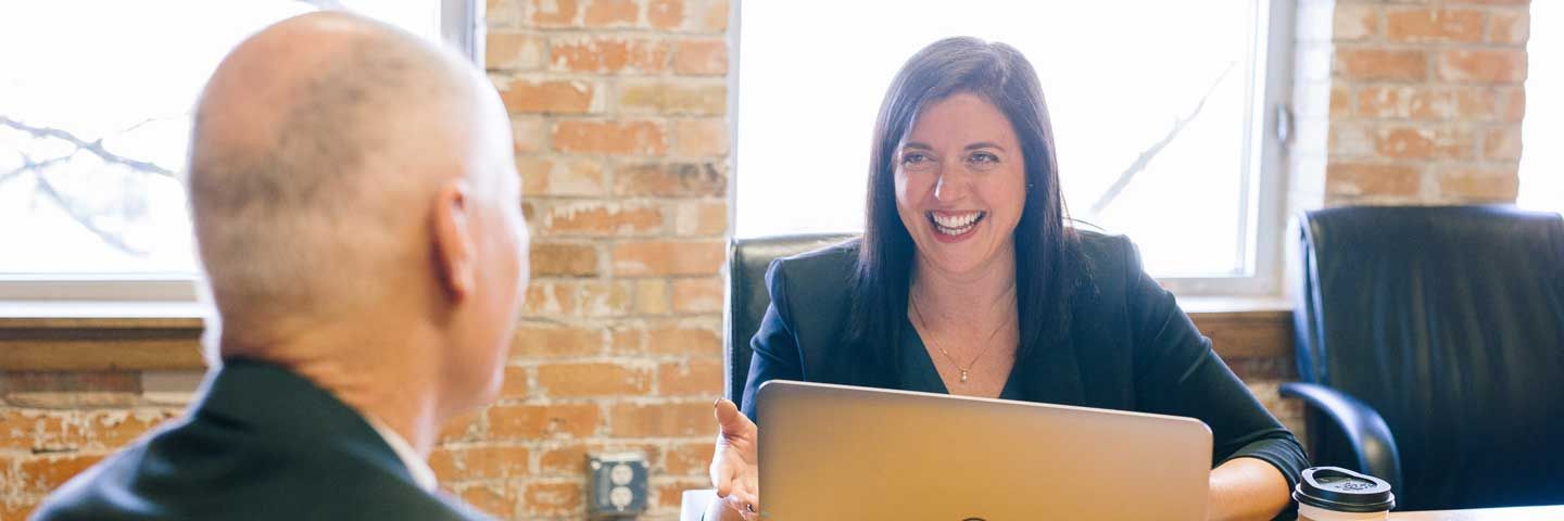 Woman and man talking smiling with laptop
