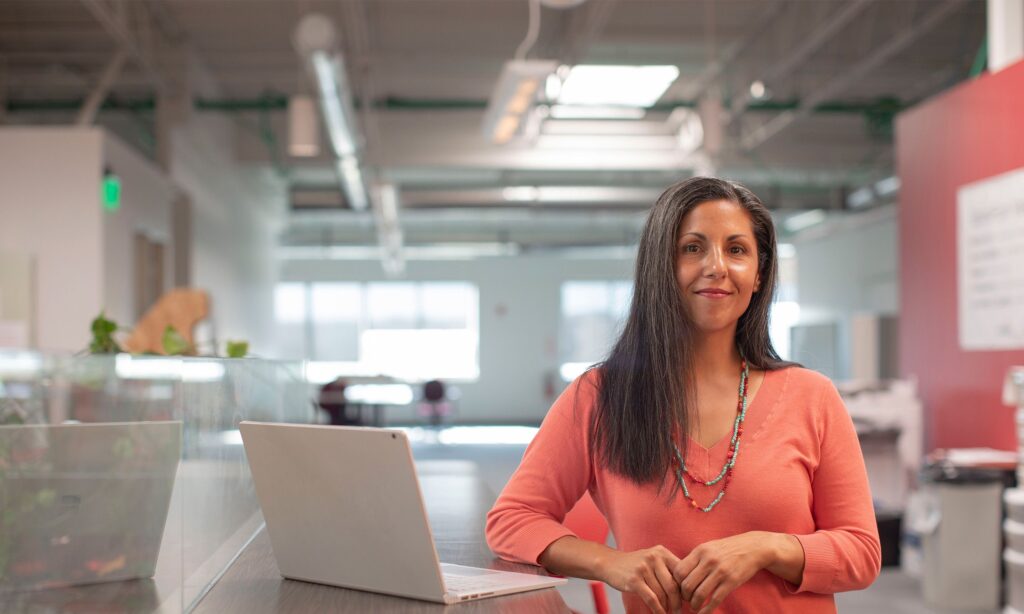 Woman standing near a laptop