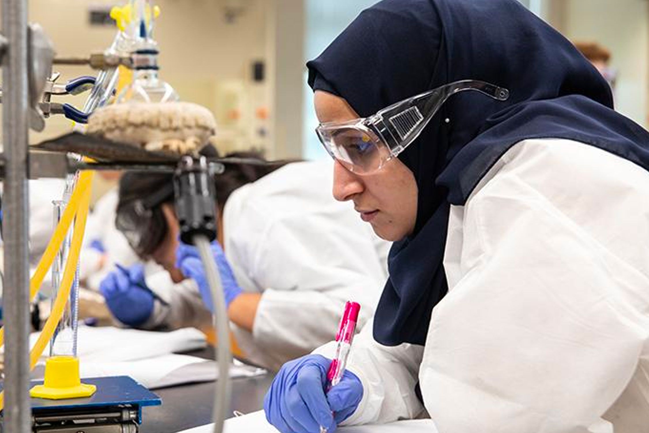 Female with safety glasses working in a lab
