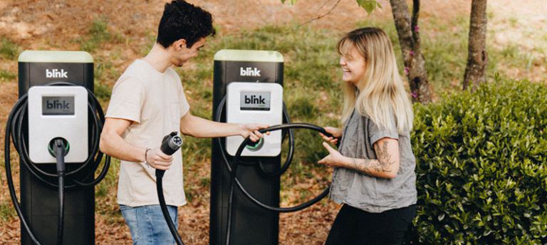 Man using electric vehicle charging station
