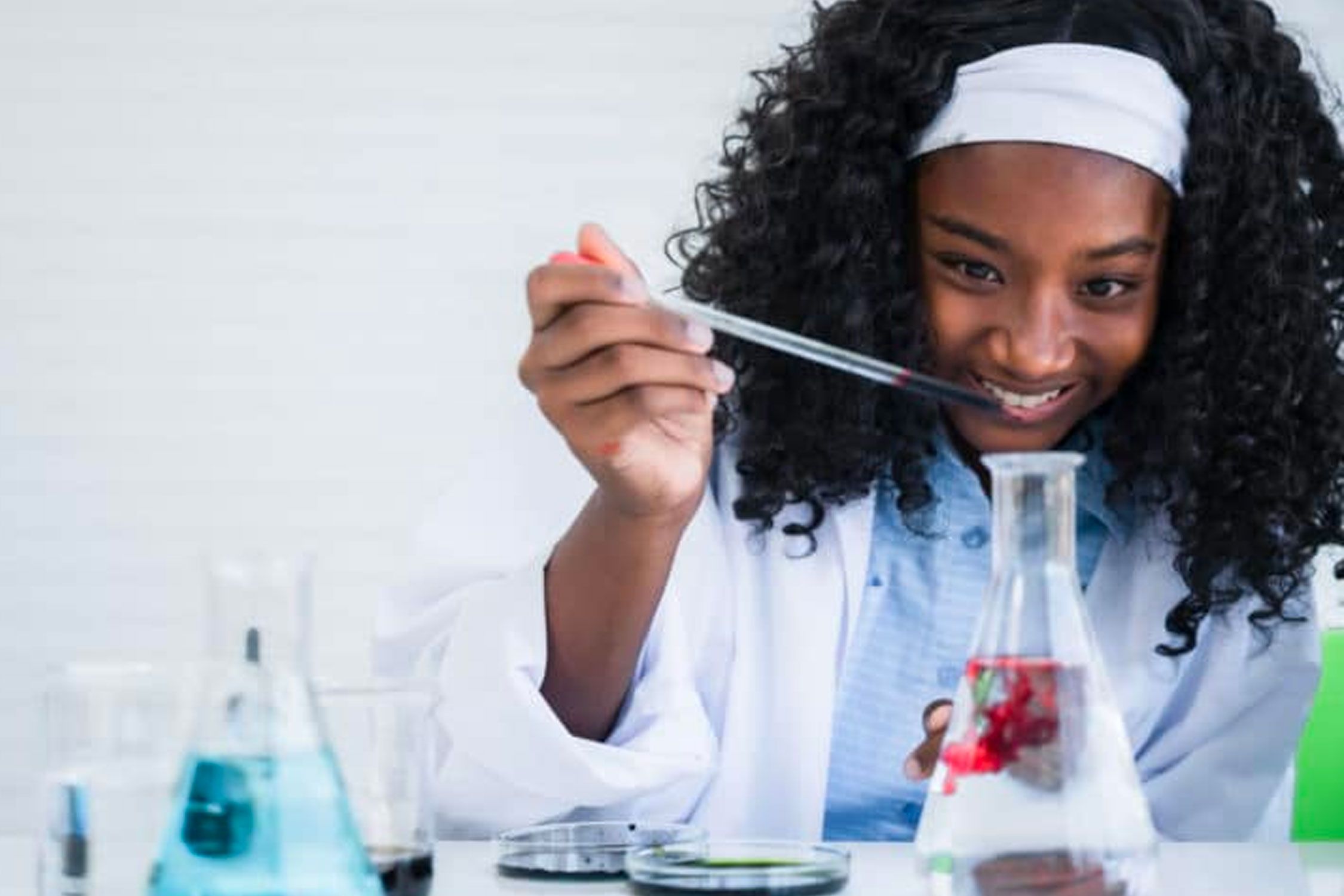 Young female using a pipette and science beaker