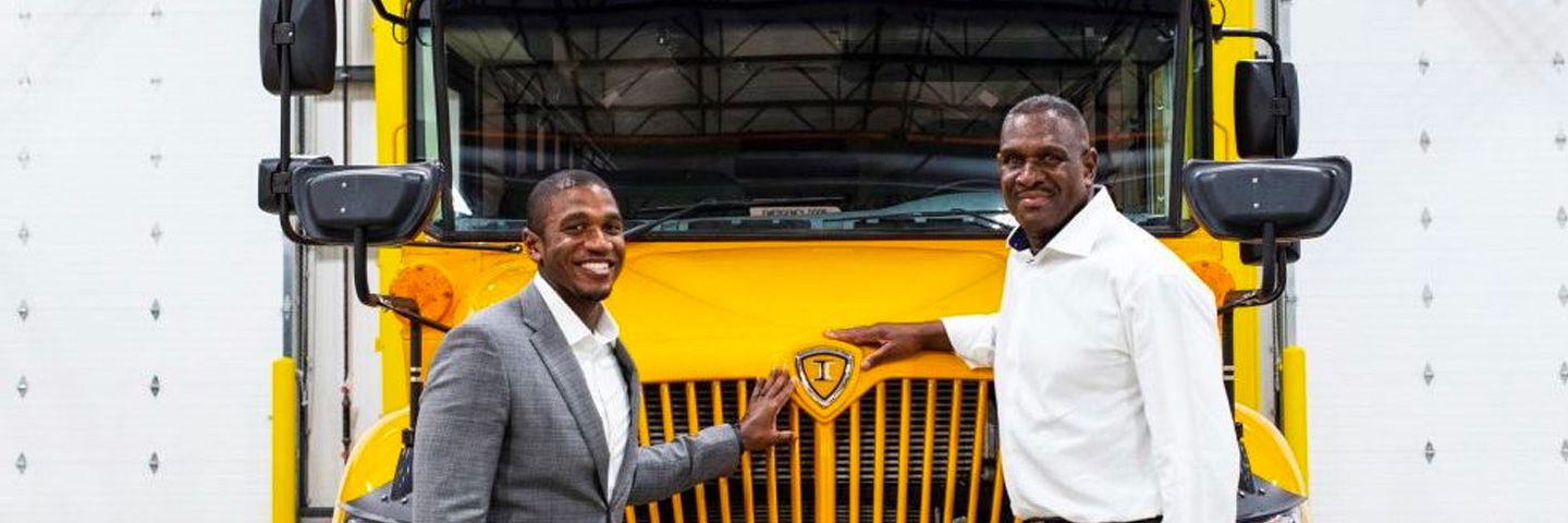 Two men in front of parked school bus