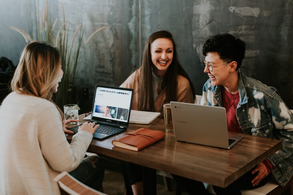 Image of people smiling and laughing at computers