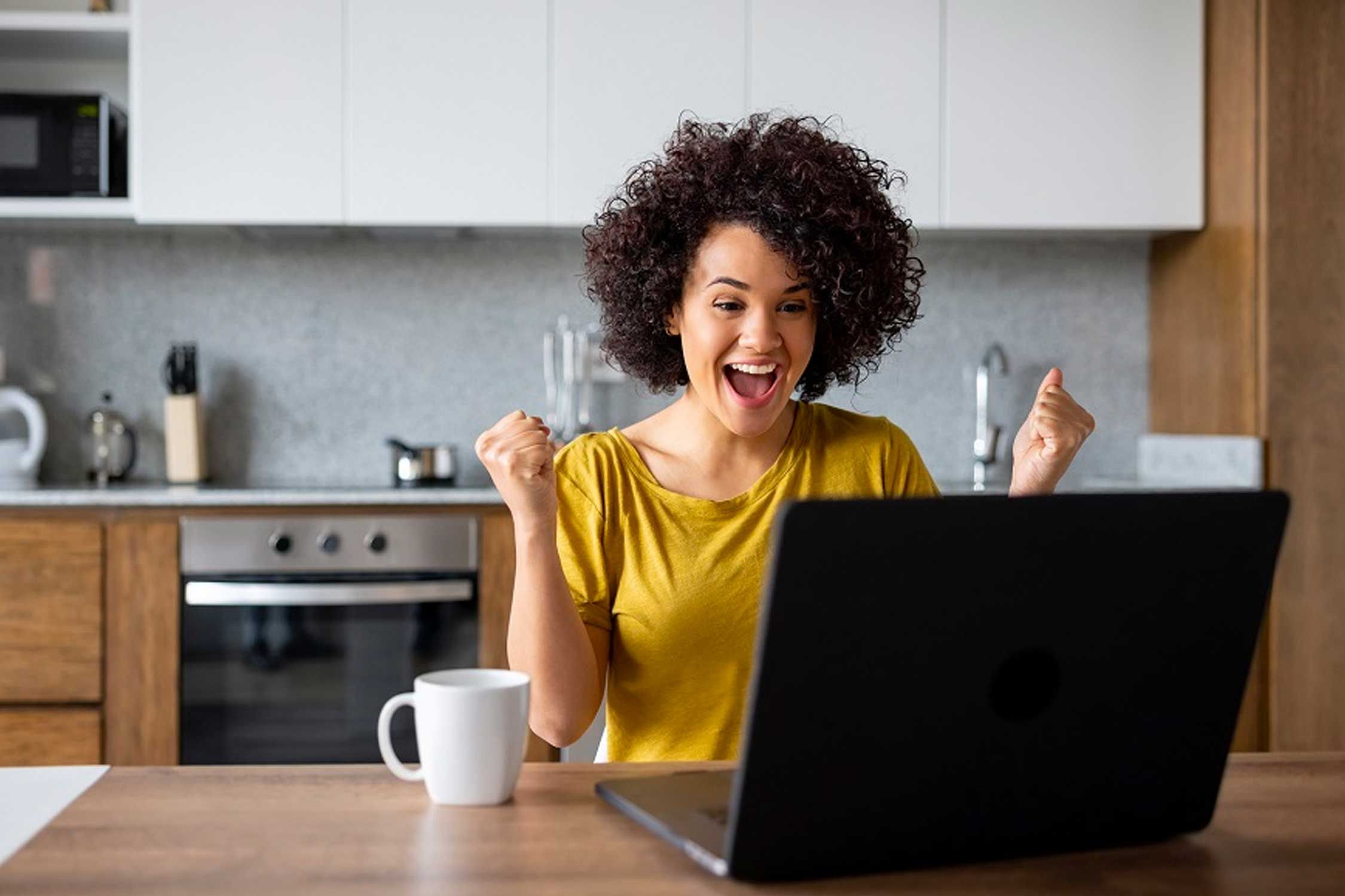 Woman celebrating in front of a computer screen