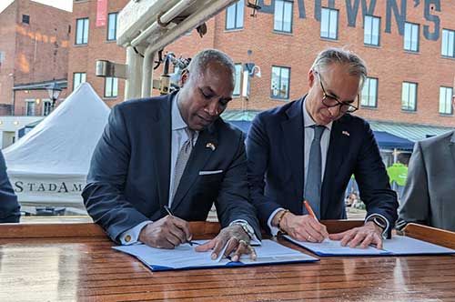 Maryland Commerce Secretary Kevin Anderson and InnovationQuarter Head of Internationalization Chris van Voorden sign MOU