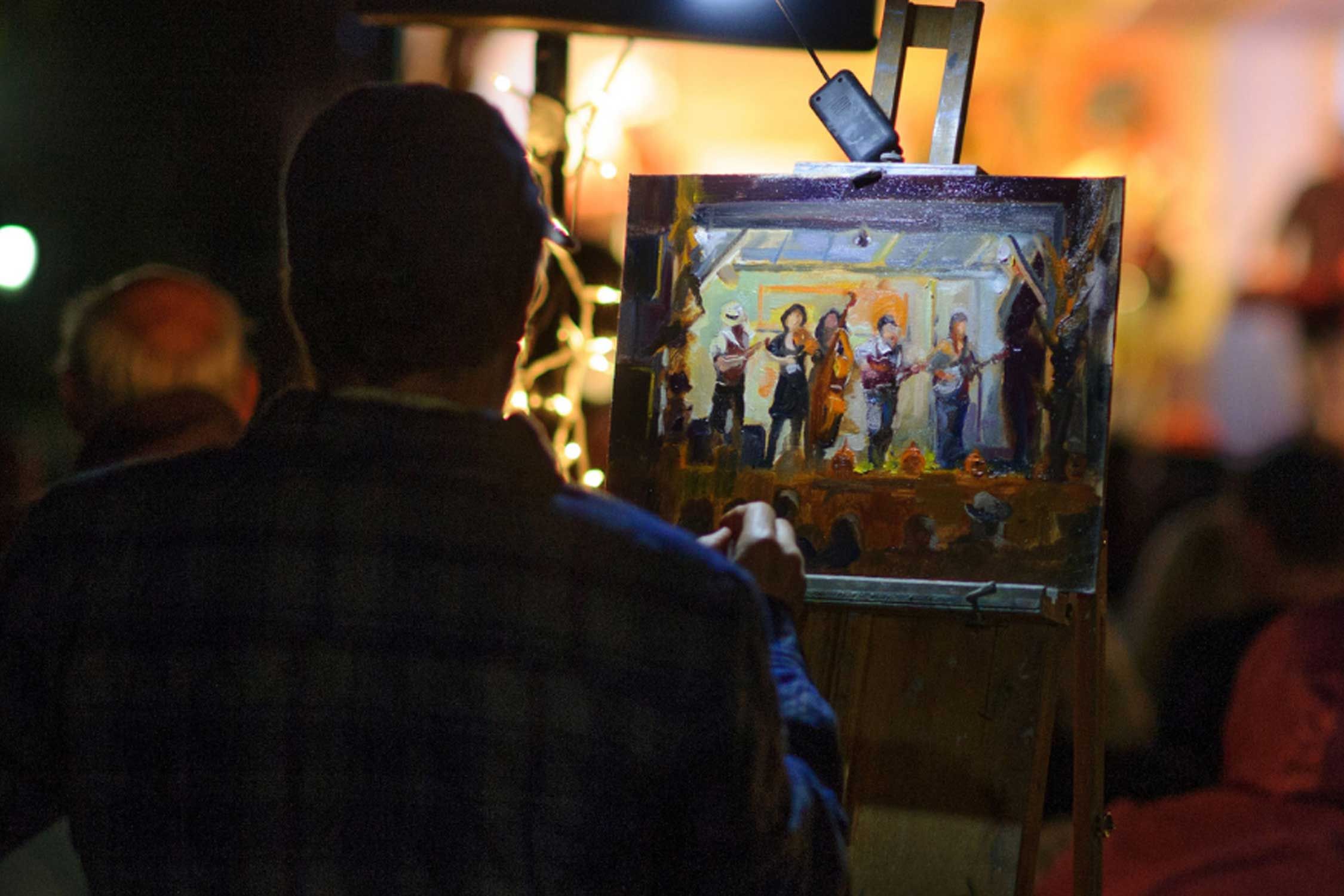 a person paints an image of a live musical performance