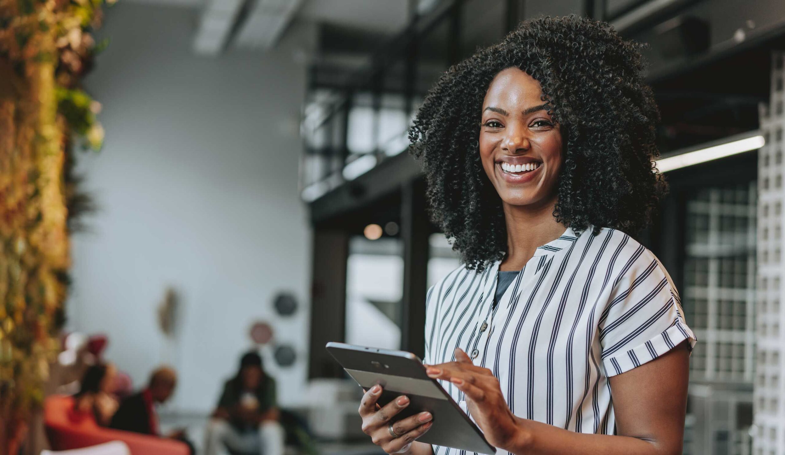 A woman smiling holding a tablet
