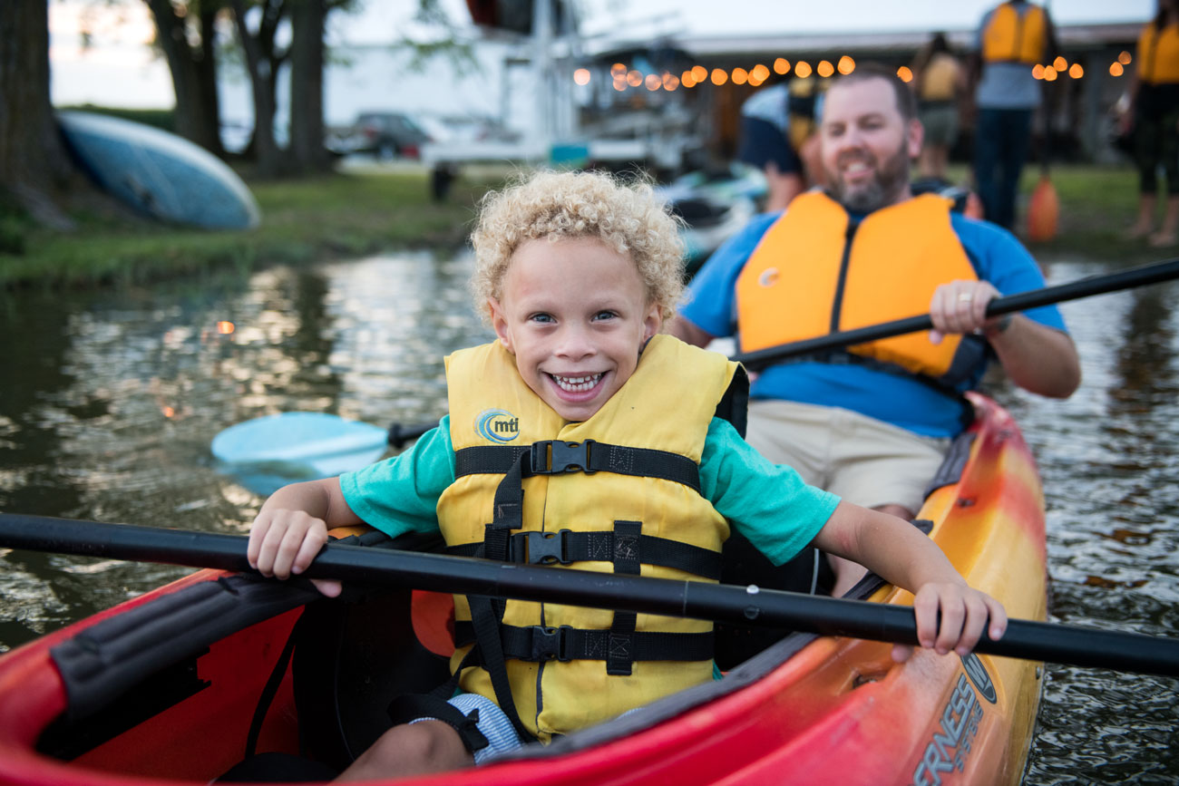 A kid in a kayak smiling at Blackwater Adventures
