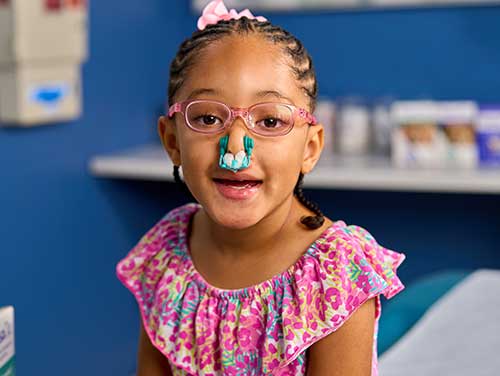 A young girl wearing the NasaClip on her nose