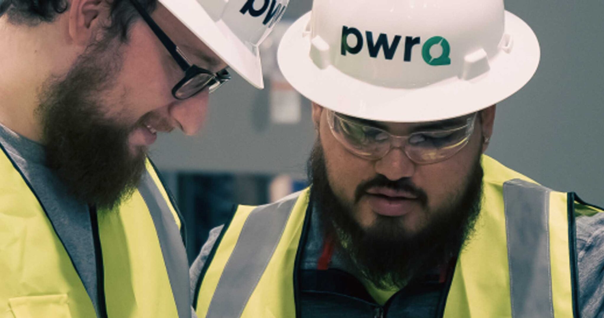 two male PwrQ workers with beards wearing hardhats
