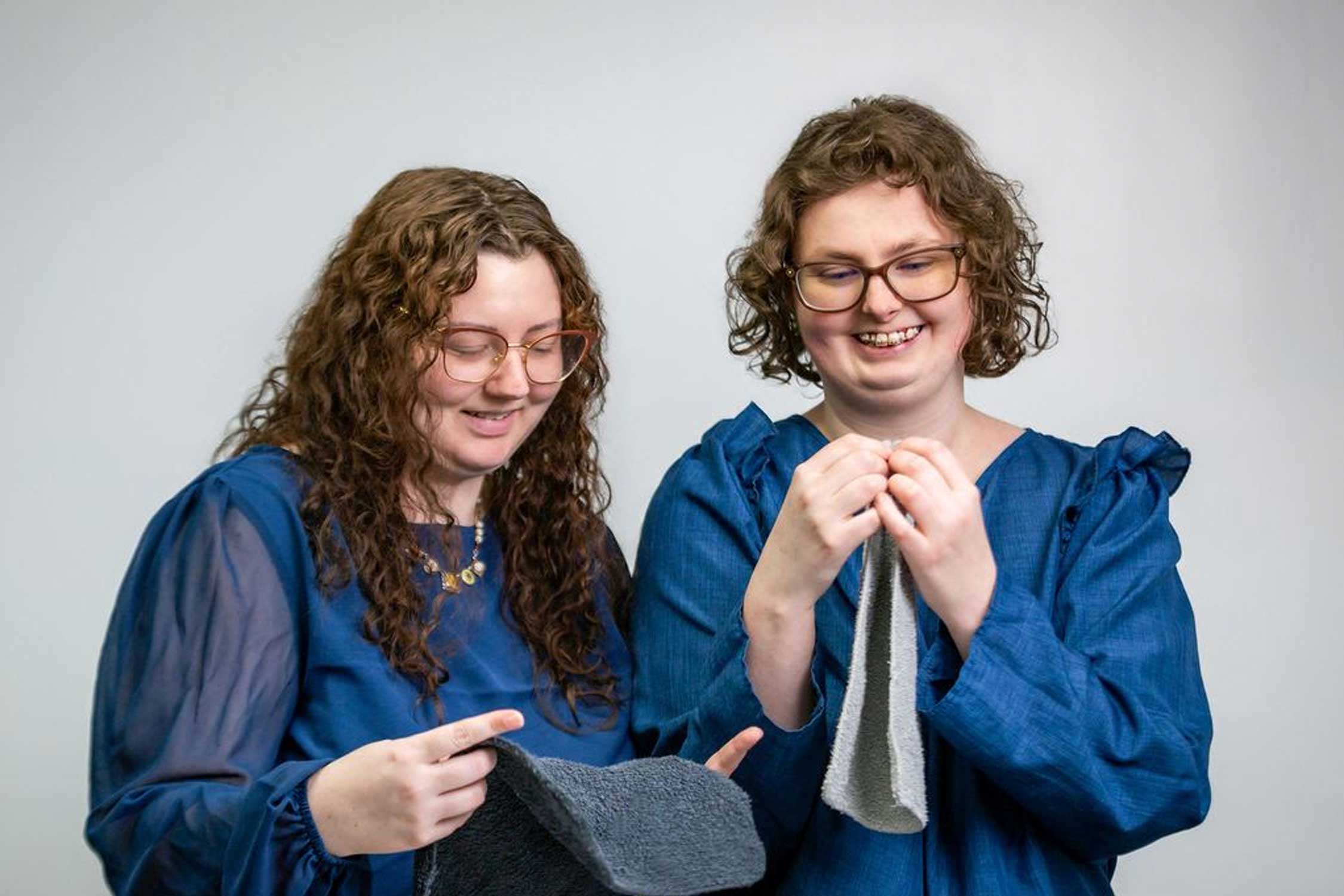 two sisters holding pieces of laundry