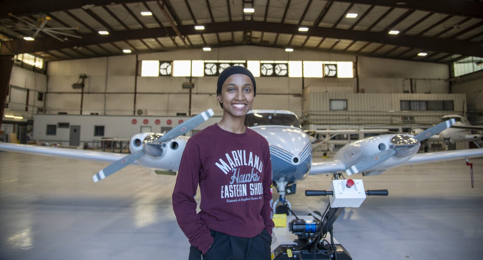A University of Maryland Eastern Shore students smiles in front of an airplane
