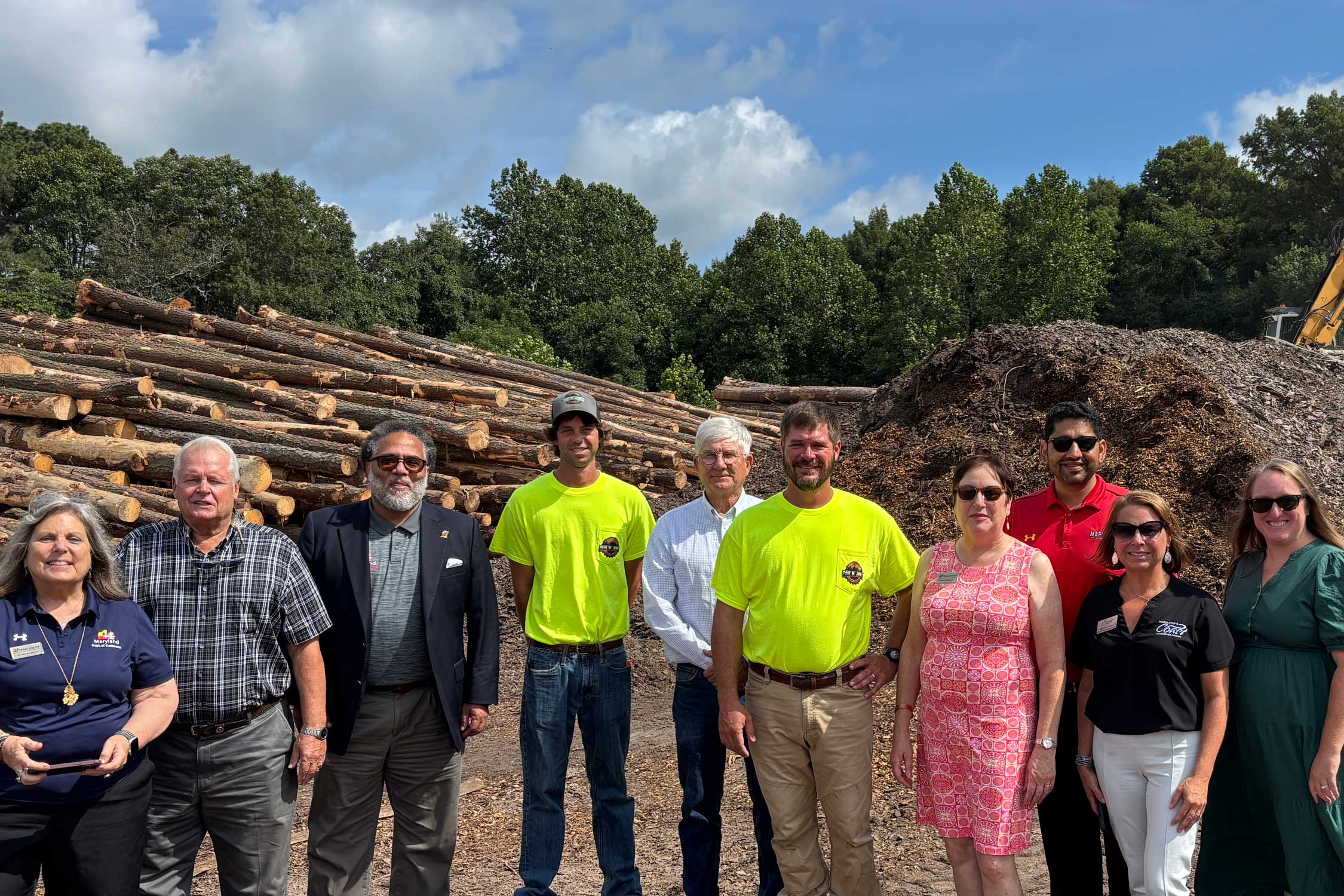 the Commerce team and Paul Jones Lumber owners pose in front of the lumber yard
