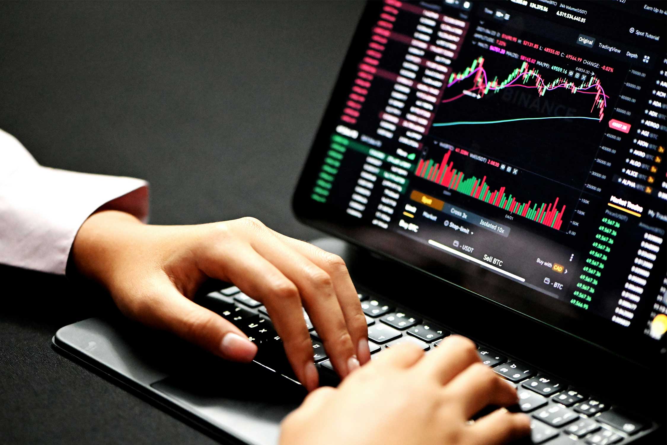 hands typing on a laptop with charts