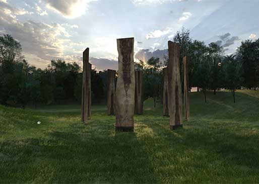wood slabs standing in a grassy field
