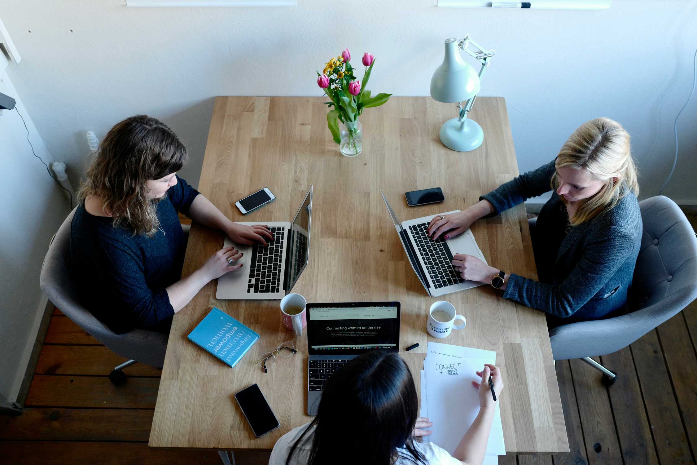 coworkers working on laptops around a table