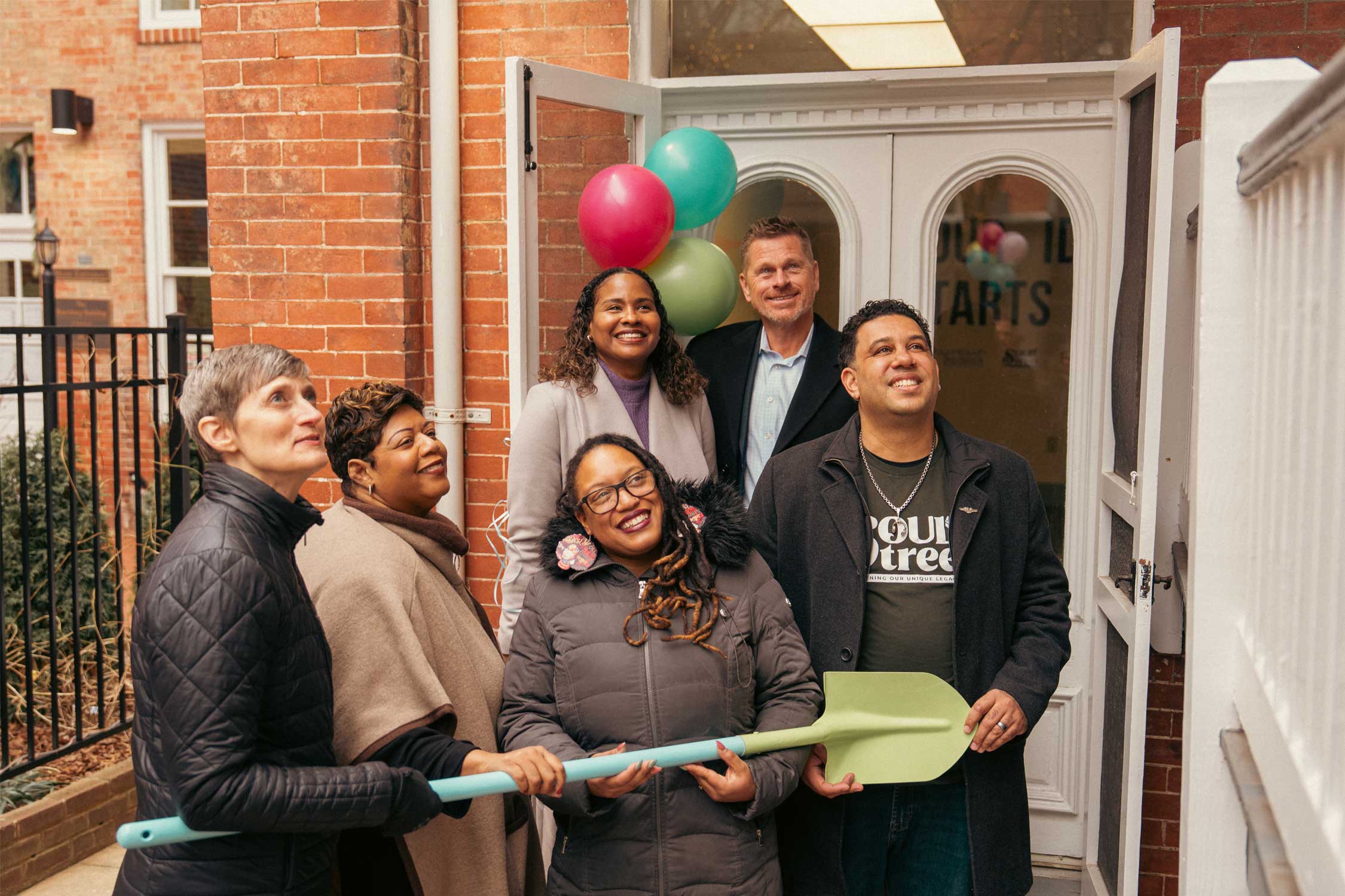 people holding a shovel at a grand opening celebration