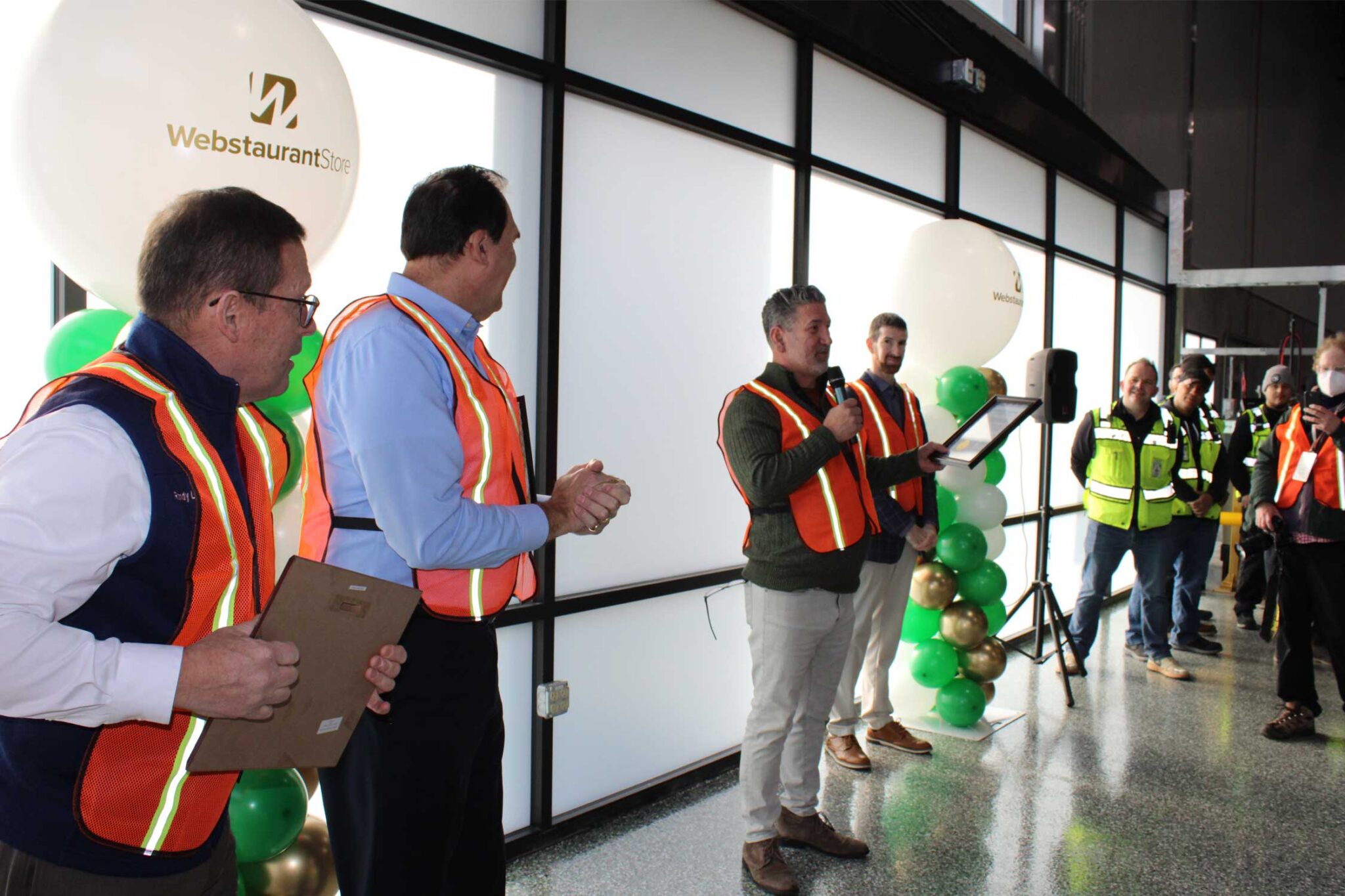 employees speaking around balloons during a grand opening event