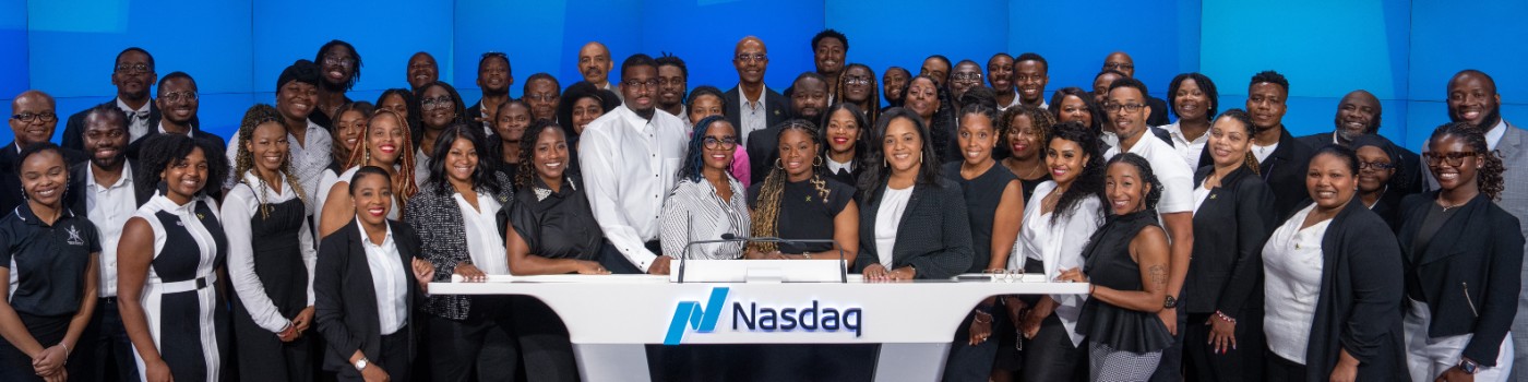 group of people standing at a NASDAQ podium