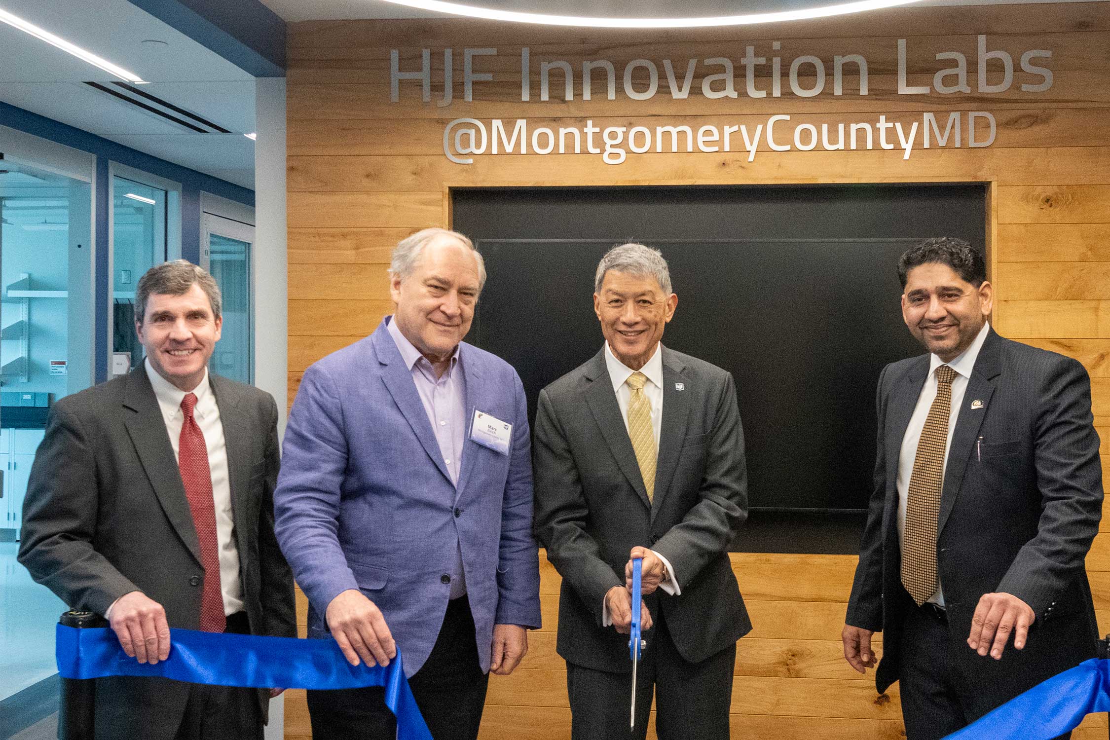 Attendees cut a ribbon at the new HJF facility in Montgomery County