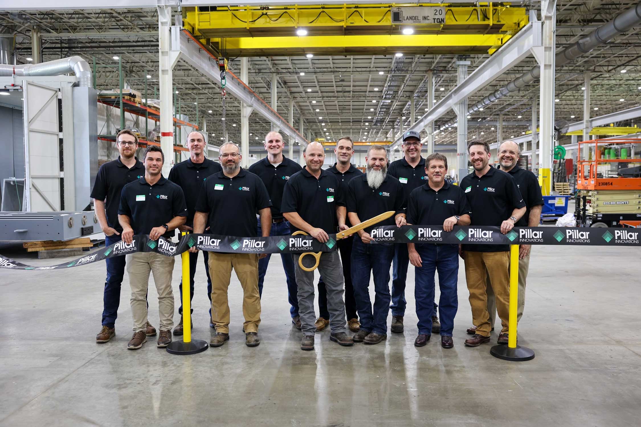 the Pillar Innovations team stands in their new space and cuts a grand opening ribbon