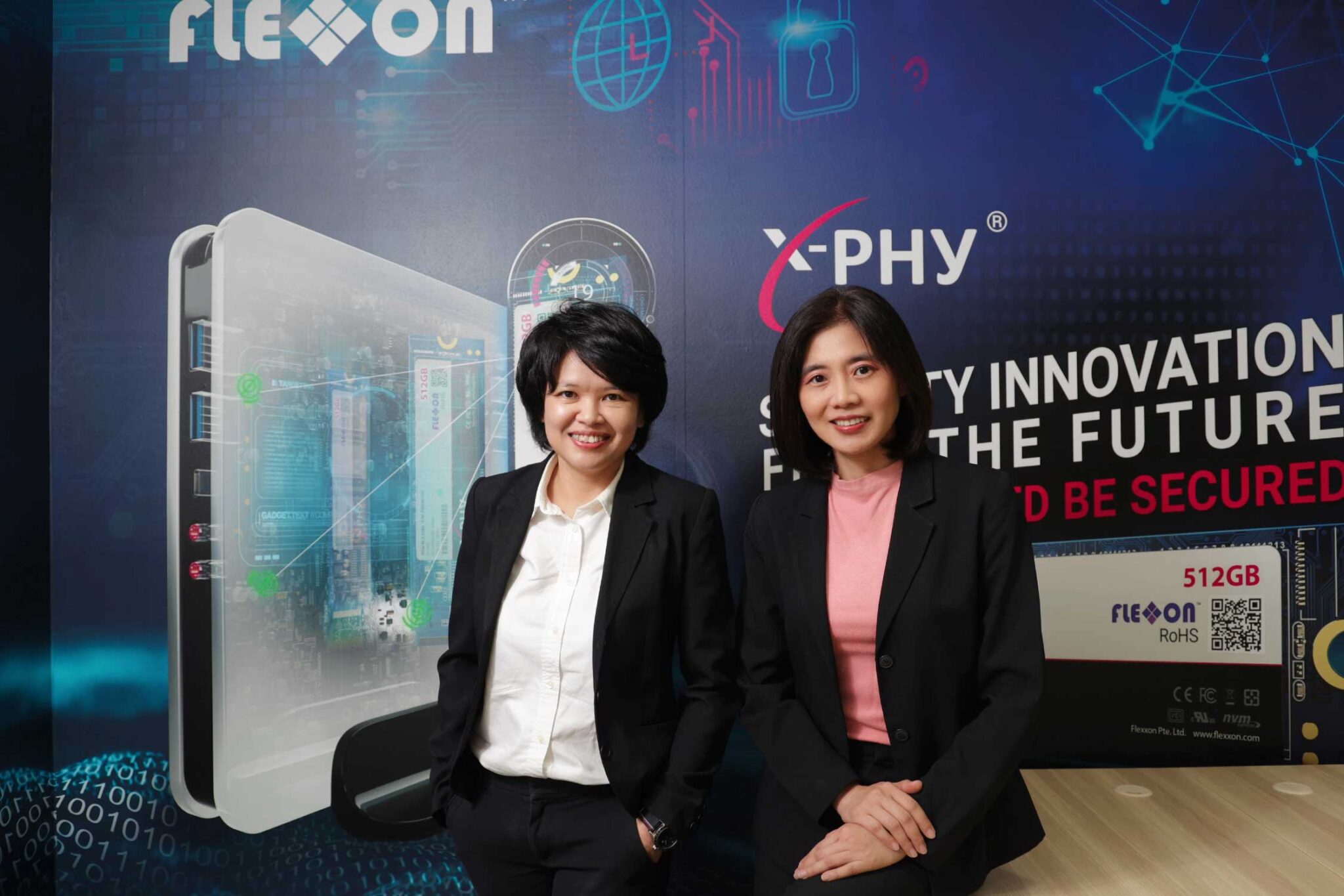 X-PHY workers pose in front of a blue backdrop